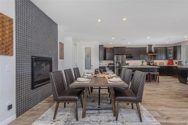 38550 Crossover Rd, Temecula, CA 92592 - dining room with light wood-style floors, a tiled fireplace, recessed lighting, and baseboards