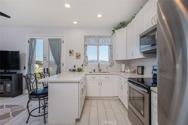 38550 Crossover Rd, Temecula, CA 92592 - kitchen featuring stainless steel appliances, a sink, a peninsula, a kitchen breakfast bar, and light countertops