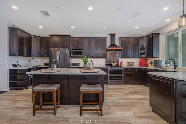38550 Crossover Rd, Temecula, CA 92592 - kitchen featuring stainless steel appliances, wall chimney exhaust hood, a sink, a breakfast bar, and light countertops