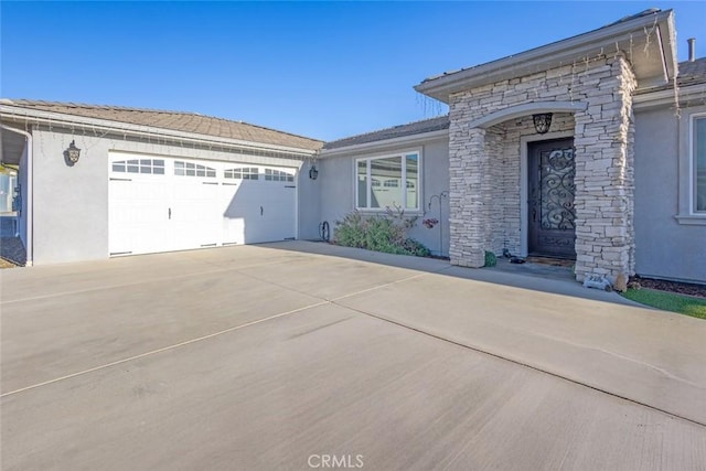 38550 Crossover Rd, Temecula, CA 92592 - view of front of property featuring concrete driveway, stucco siding, an attached garage, and stone siding