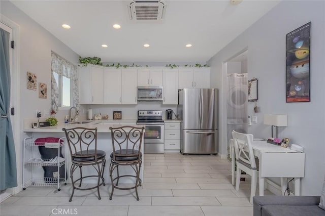38550 Crossover Rd, Temecula, CA 92592 - kitchen with stainless steel appliances, a peninsula, a kitchen breakfast bar, recessed lighting, and light countertops