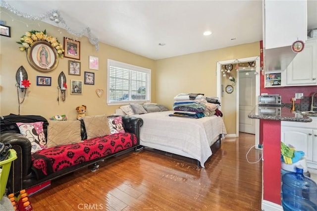 bedroom with hardwood / wood-style floors and a sink
