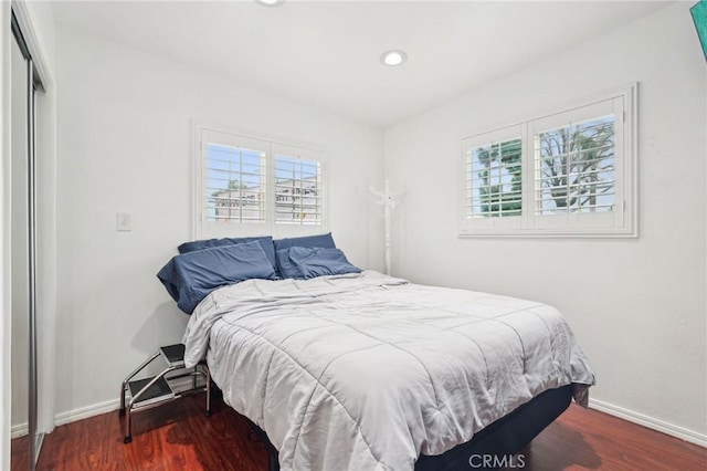 bedroom featuring wood finished floors, baseboards, and recessed lighting