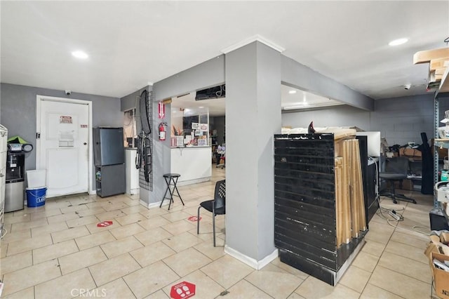 finished below grade area with freestanding refrigerator, recessed lighting, and baseboards
