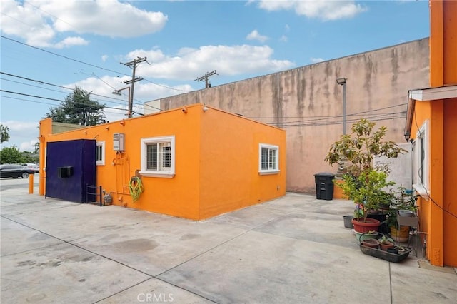 view of side of home with a patio area and stucco siding