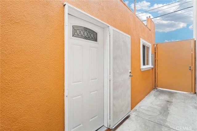 property entrance with stucco siding