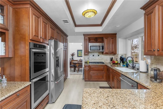 744 Clearview Ln, San Luis Obispo, CA 93405 - kitchen featuring stainless steel appliances, a sink, a tray ceiling, light wood finished floors, and light stone countertops