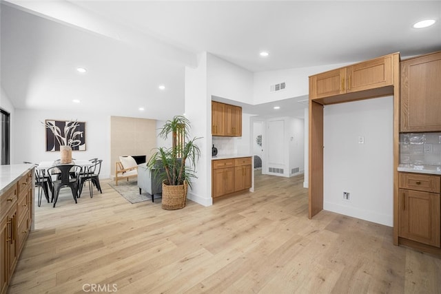16009 Jalon Rd, La Mirada, CA 90638 - kitchen featuring light wood-style flooring, light countertops, recessed lighting, vaulted ceiling, and brown cabinets