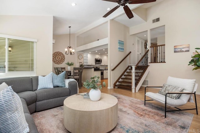 1715 Kennington Rd, Encinitas, CA 92024 - living area with light wood-type flooring, ceiling fan, stairs, a chandelier, and high vaulted ceiling