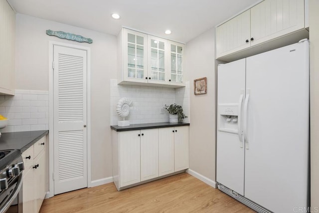 1715 Kennington Rd, Encinitas, CA 92024 - kitchen featuring white fridge with ice dispenser, dark countertops, tasteful backsplash, light wood-style flooring, and recessed lighting
