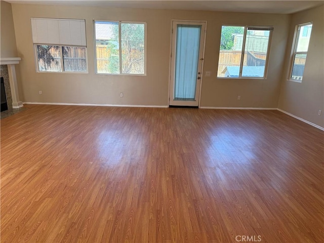 11946 Russell Ct, Victorville, CA 92392 - unfurnished living room featuring wood finished floors, a tile fireplace, and baseboards