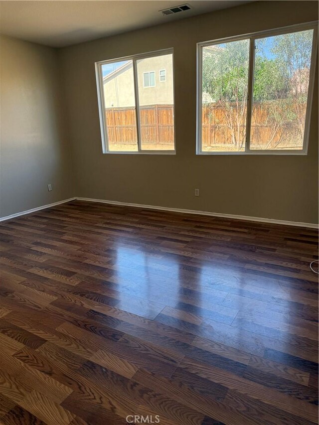 11946 Russell Ct, Victorville, CA 92392 - unfurnished room featuring healthy amount of natural light, baseboards, and dark wood-style flooring