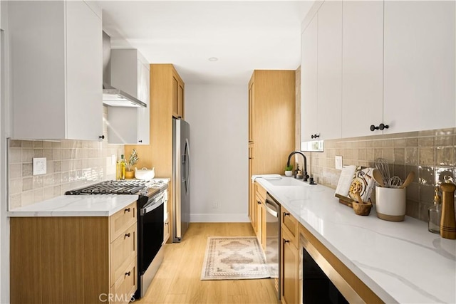 6340 Charlwood St, Lakewood, CA 90713 - kitchen with appliances with stainless steel finishes, a sink, wall chimney exhaust hood, light stone counters, and light wood finished floors