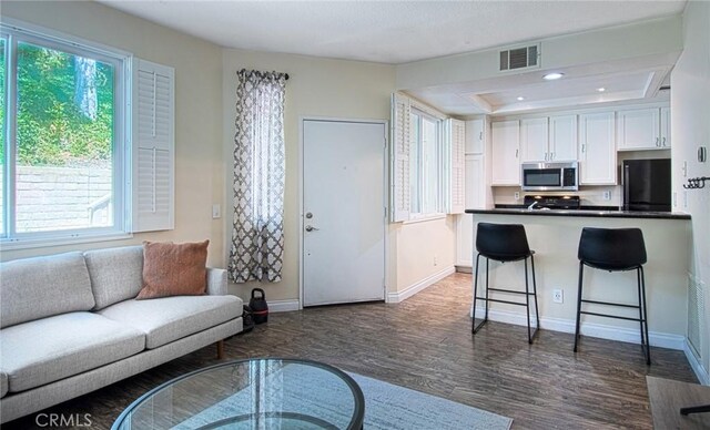 28071 Caldaro, Laguna Niguel, CA 92677 - living room featuring dark wood-style flooring, healthy amount of natural light, baseboards, recessed lighting, and a tray ceiling