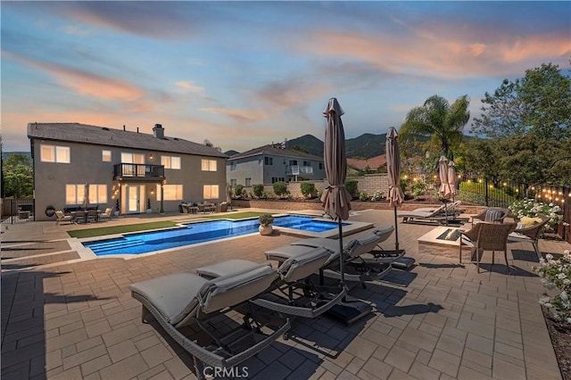 1663 Spyglass Dr, Corona, CA 92883 - pool at dusk featuring a patio area, fence, and a pool with connected hot tub