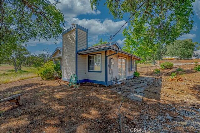 5030 Creek Front Rd, Catheys Valley, CA 95306 - back of property featuring a chimney, fence, and a patio