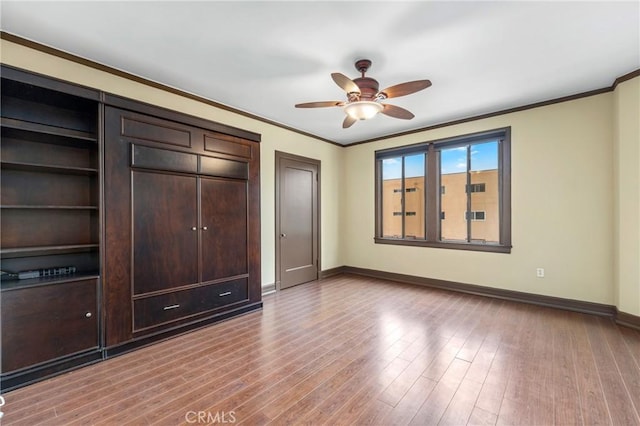 315 W 3rd St Unit 311, Long Beach, CA 90802 - unfurnished bedroom with baseboards, crown molding, wood finished floors, and a ceiling fan