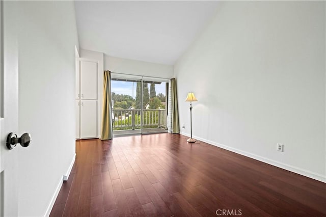 spare room featuring baseboards and dark wood-style flooring