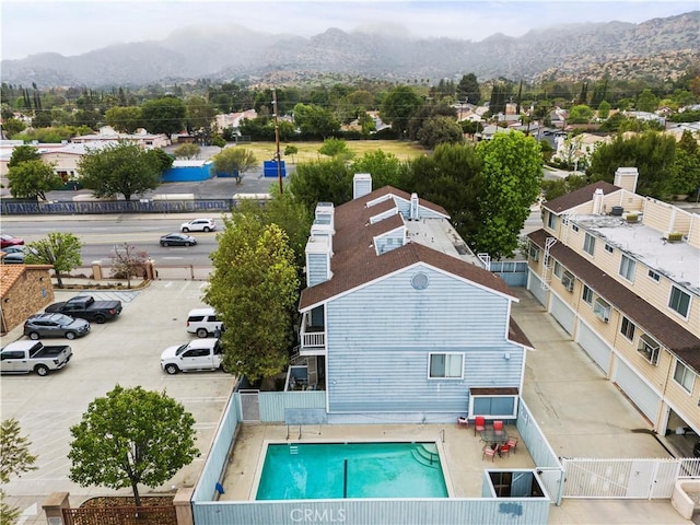 aerial view of property and surrounding area with mountains and a pool area