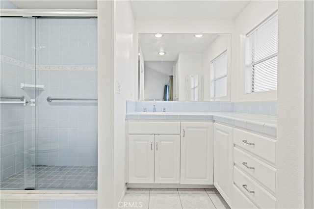 bathroom featuring tile patterned flooring, a shower stall, vanity, and recessed lighting