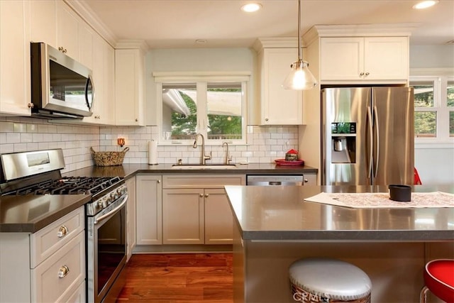 225 Hacienda Ave, San Luis Obispo, CA 93401 - kitchen featuring a sink, stainless steel appliances, dark countertops, a breakfast bar, and dark wood-type flooring