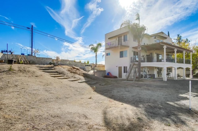 2638 W Victoria Dr, Alpine, CA 91901 - rear view of house featuring a balcony, stucco siding, and stairway