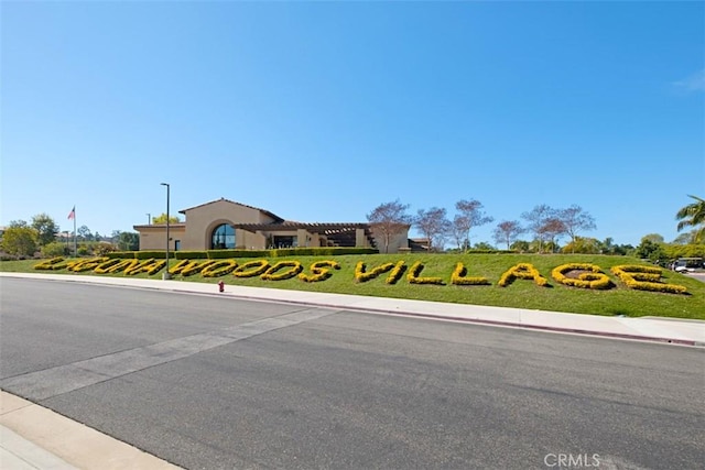 2319 Via Puerta Unit O, Laguna Woods, CA 92637 - view of asphalt road featuring street lights, sidewalks, and curbs