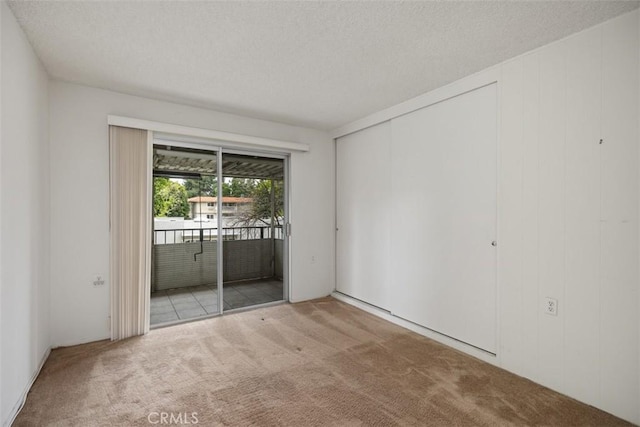 2319 Via Puerta Unit O, Laguna Woods, CA 92637 - unfurnished bedroom with carpet flooring, access to outside, and a textured ceiling