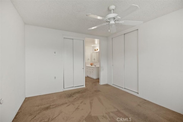 2319 Via Puerta Unit O, Laguna Woods, CA 92637 - unfurnished bedroom featuring carpet floors, a textured ceiling, ceiling fan, and two closets