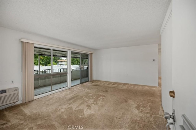2319 Via Puerta Unit O, Laguna Woods, CA 92637 - carpeted empty room with a textured ceiling and a wall unit AC