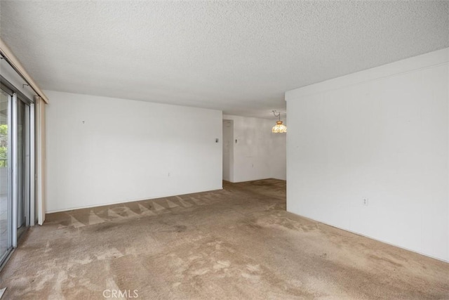2319 Via Puerta Unit O, Laguna Woods, CA 92637 - empty room featuring carpet floors, a textured ceiling, and a chandelier