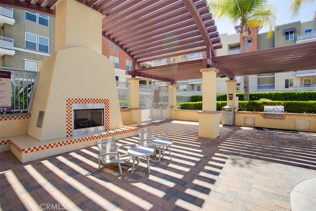 12668 Chapman Ave Unit 2403, Garden Grove, CA 92840 - view of patio featuring exterior kitchen, a pergola, and a fireplace
