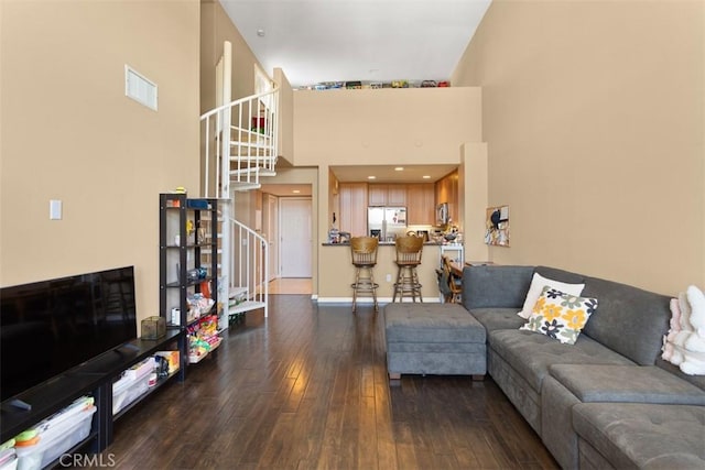 12668 Chapman Ave Unit 2403, Garden Grove, CA 92840 - living room with stairway, hardwood / wood-style flooring, a towering ceiling, and baseboards