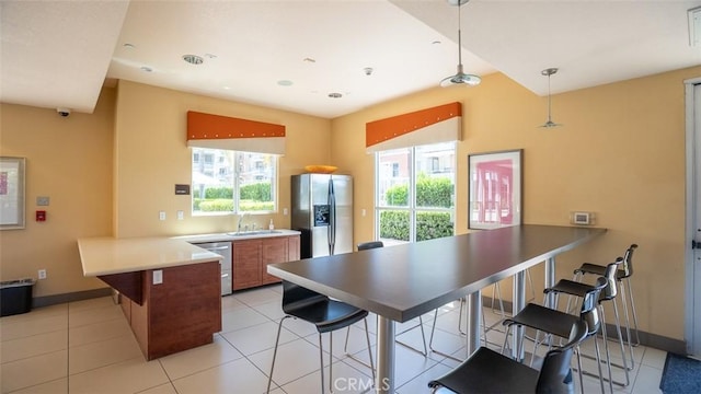 12668 Chapman Ave Unit 2403, Garden Grove, CA 92840 - kitchen featuring a peninsula, appliances with stainless steel finishes, a sink, brown cabinets, and a breakfast bar