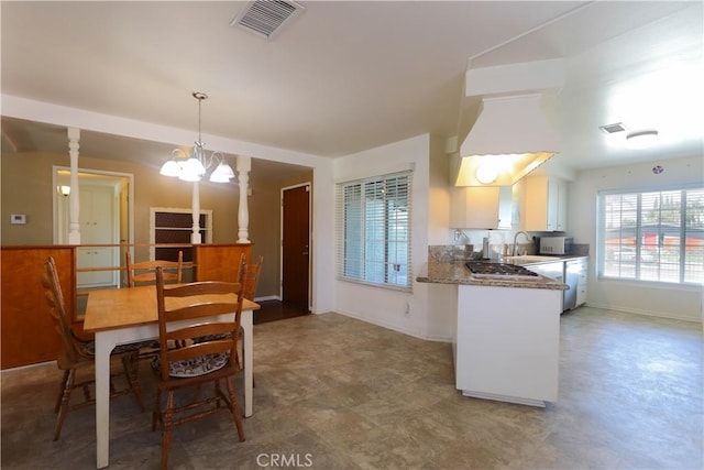 9943 Vernon Ave, Montclair, CA 91763 - kitchen featuring a chandelier, white cabinetry, a sink, baseboards, and pendant lighting