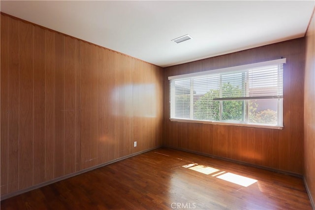 9943 Vernon Ave, Montclair, CA 91763 - unfurnished room with plenty of natural light, wood finished floors, and wooden walls
