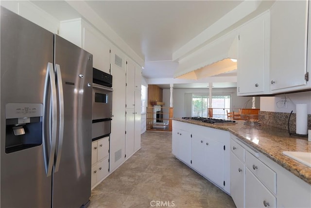 9943 Vernon Ave, Montclair, CA 91763 - kitchen featuring stainless steel appliances, a warming drawer, white cabinets, light stone countertops, and a peninsula