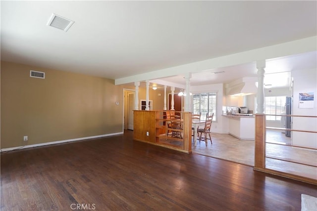 9943 Vernon Ave, Montclair, CA 91763 - living area featuring wood finished floors, decorative columns, and baseboards
