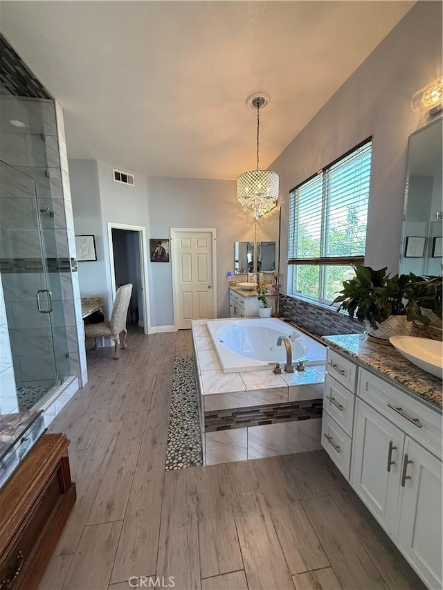 17287 Grove Dr, Riverside, CA 92503 - full bath with a shower stall, a chandelier, a bath, wood finished floors, and two vanities