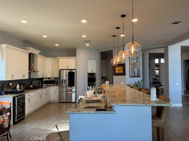 17287 Grove Dr, Riverside, CA 92503 - kitchen featuring appliances with stainless steel finishes, wine cooler, a sink, white cabinets, and recessed lighting