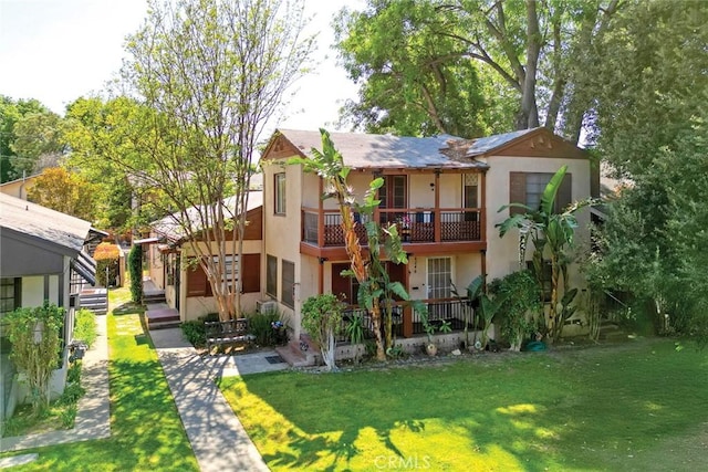 4250 10th St, Riverside, CA 92501 - rear view of house featuring a balcony, stucco siding, and a yard