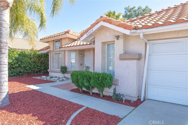 43419 Olive Ave, Hemet, CA 92544 - view of exterior entry featuring a tiled roof, stucco siding, and a garage