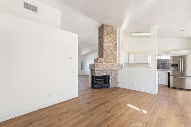 43419 Olive Ave, Hemet, CA 92544 - unfurnished living room featuring light wood finished floors, a sink, baseboards, and vaulted ceiling