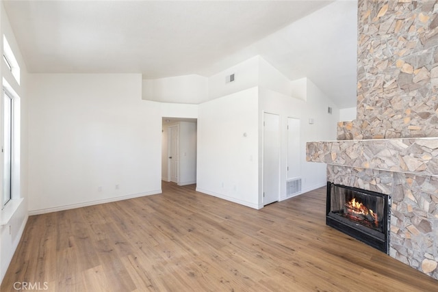 43419 Olive Ave, Hemet, CA 92544 - unfurnished living room featuring a stone fireplace, wood finished floors, baseboards, and lofted ceiling