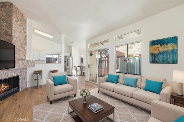 43419 Olive Ave, Hemet, CA 92544 - living area featuring light wood finished floors, a stone fireplace, and lofted ceiling