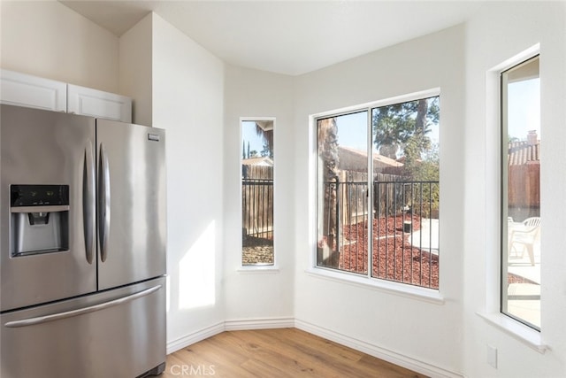 43419 Olive Ave, Hemet, CA 92544 - kitchen with stainless steel fridge, light wood-style flooring, baseboards, and white cabinetry