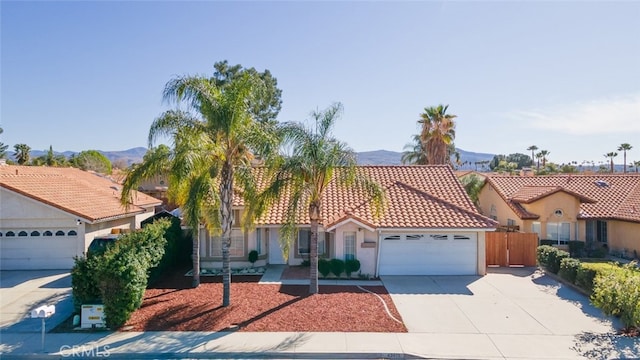 43419 Olive Ave, Hemet, CA 92544 - mediterranean / spanish house featuring an attached garage, driveway, a mountain view, stucco siding, and a tiled roof