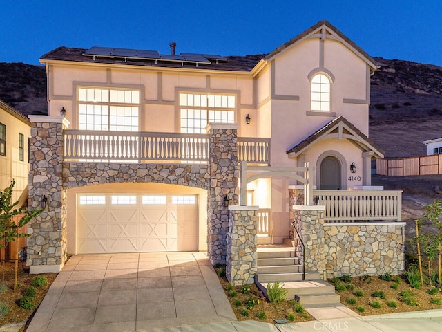 4140 Hillside Dr, San Luis Obispo, CA 93401 - view of front of home with stucco siding, a garage, a balcony, and roof mounted solar panels