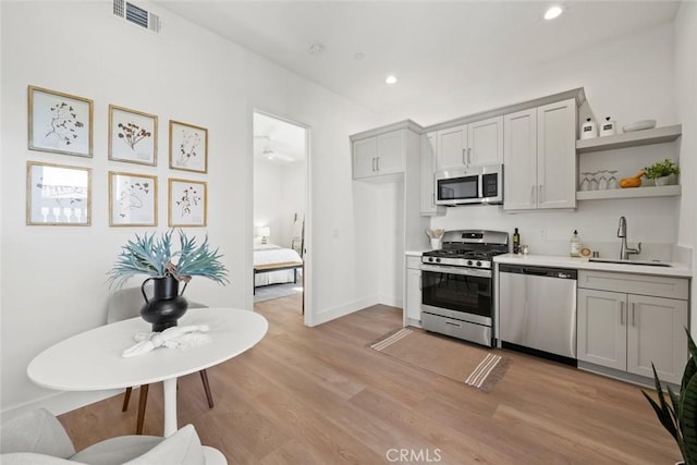 4140 Hillside Dr, San Luis Obispo, CA 93401 - kitchen with appliances with stainless steel finishes, a sink, open shelves, light countertops, and light wood-type flooring