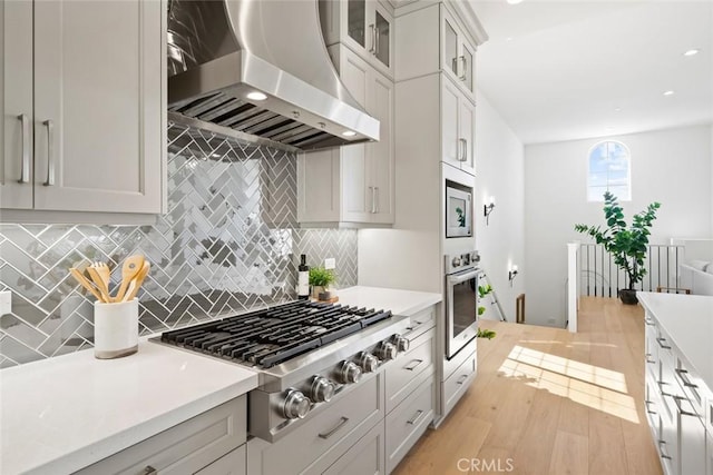 4140 Hillside Dr, San Luis Obispo, CA 93401 - kitchen featuring wall chimney range hood, appliances with stainless steel finishes, light countertops, light wood-style floors, and recessed lighting